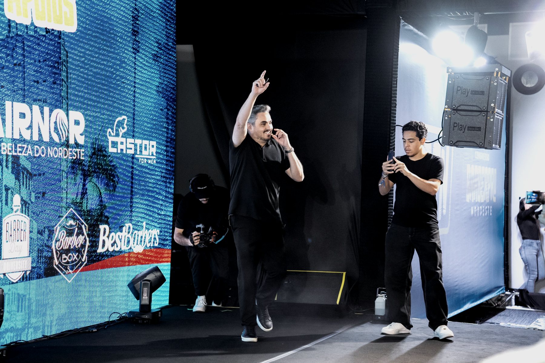 Adailton Brito entrando no palco de um congresso de barbeiros